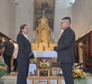 Conseillers funéraires en costume se recueillant devant l'autel d'une église.