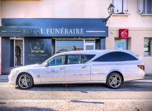 Corbillard gris stationné devant la façade de l'agence Royal Funéraire.