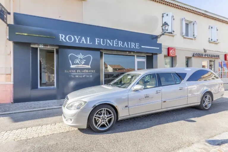 Vue en angle d'un corbillard de luxe devant la devanture de Royal Funéraire.
